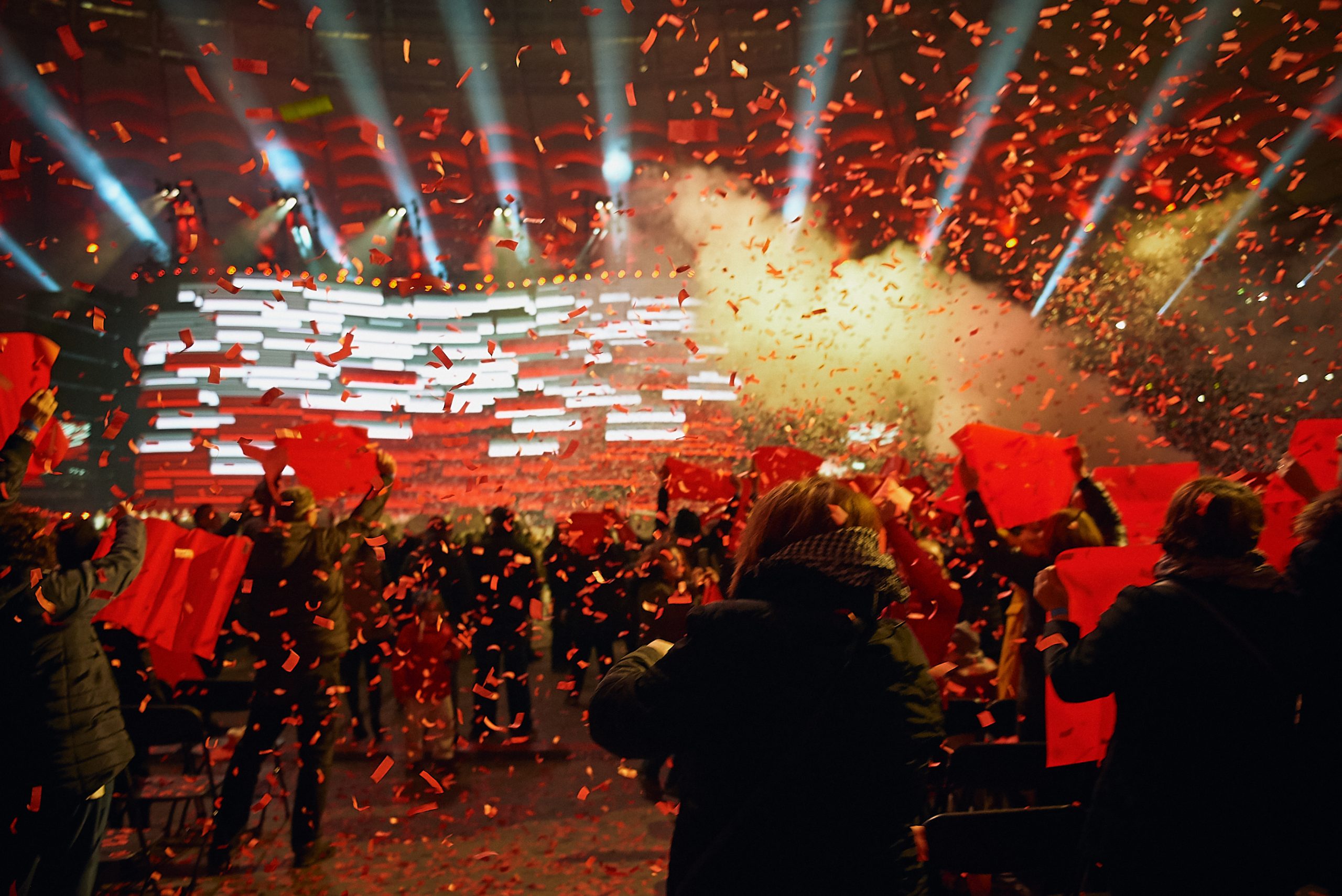 White and red illuminations, confetti in patriotic colours falling over spectators