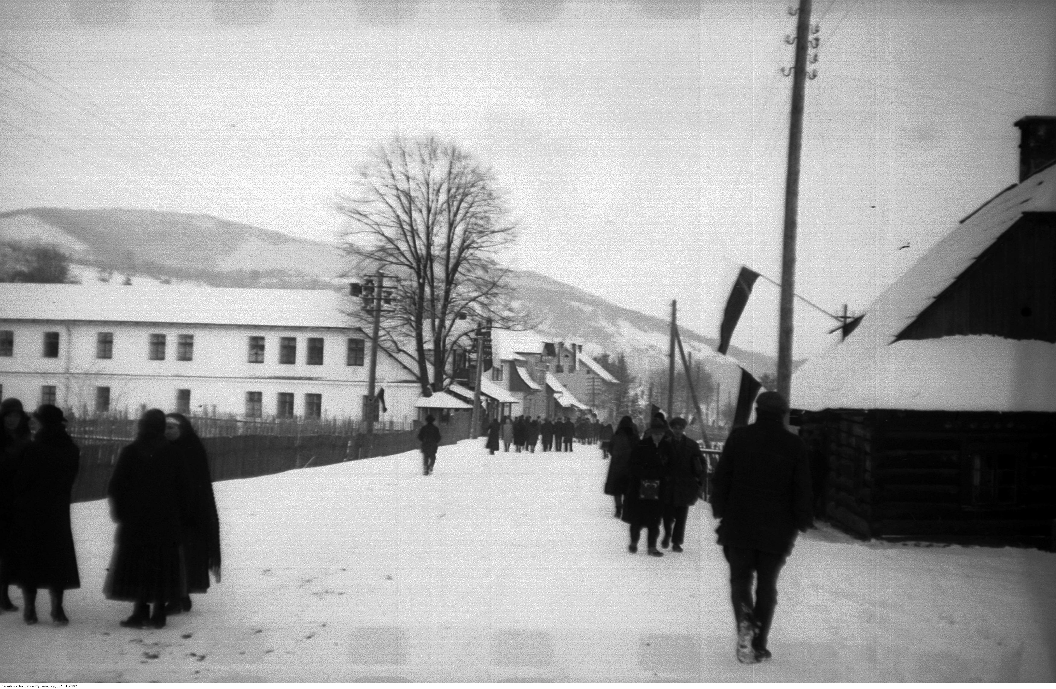 Fragment miejscowości Wisła. Fragment jednej z ulic miejscowości. Widoczni piesi. Fotografia wykonana zimą. Źródło: NAC.