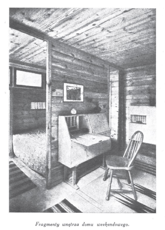 Fragmenty wnętrza domu weekendowego, widoczne składane biurko i krzesło, w tle oddzielona ścianką sypialnia