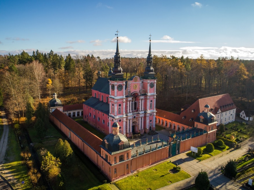 widok na fasadę katedry z dwoma wieżami otoczoną prostokątem krużganków