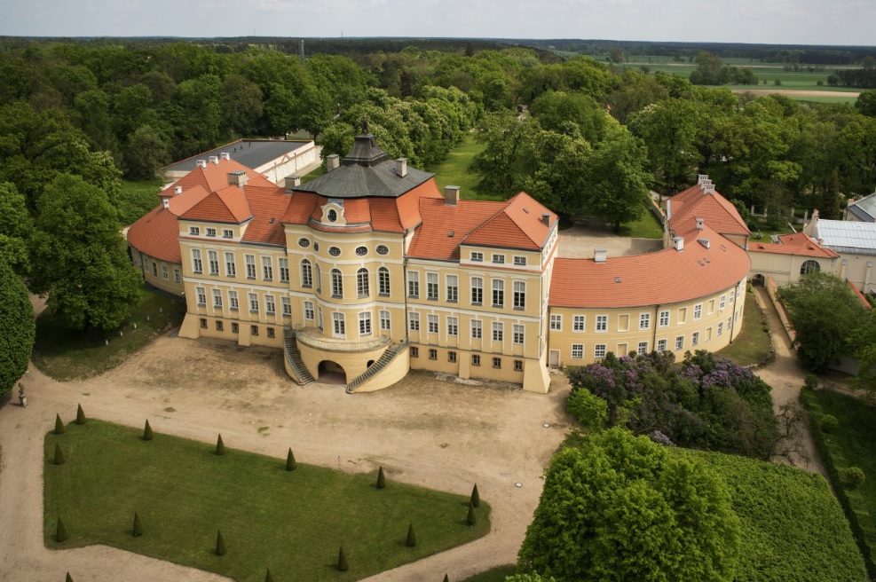 pałac wygięty w podkowę otoczony zielenią