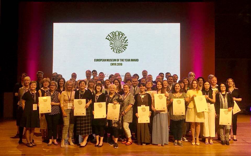 grupa elegancko ubranych ludzi prezentuje dyplomy