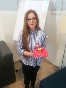 elegancko ubrana kobieta trzyma w ręce ciastko na serwecie