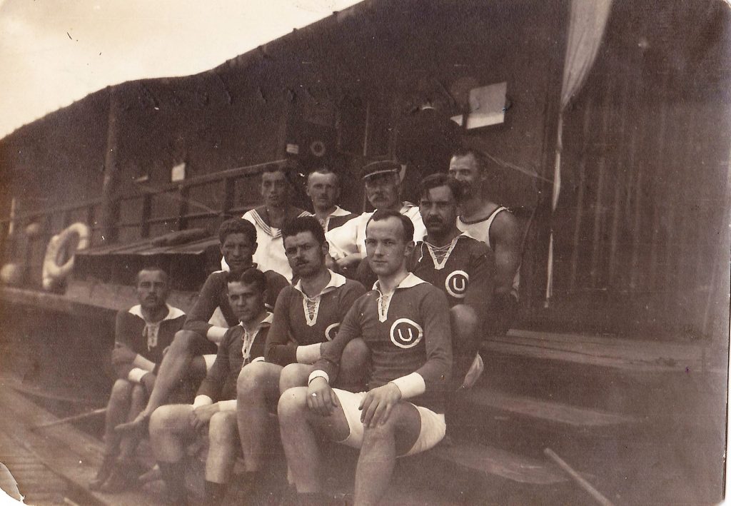 grupa mężczyzn siedzących na drewnianych stopniach