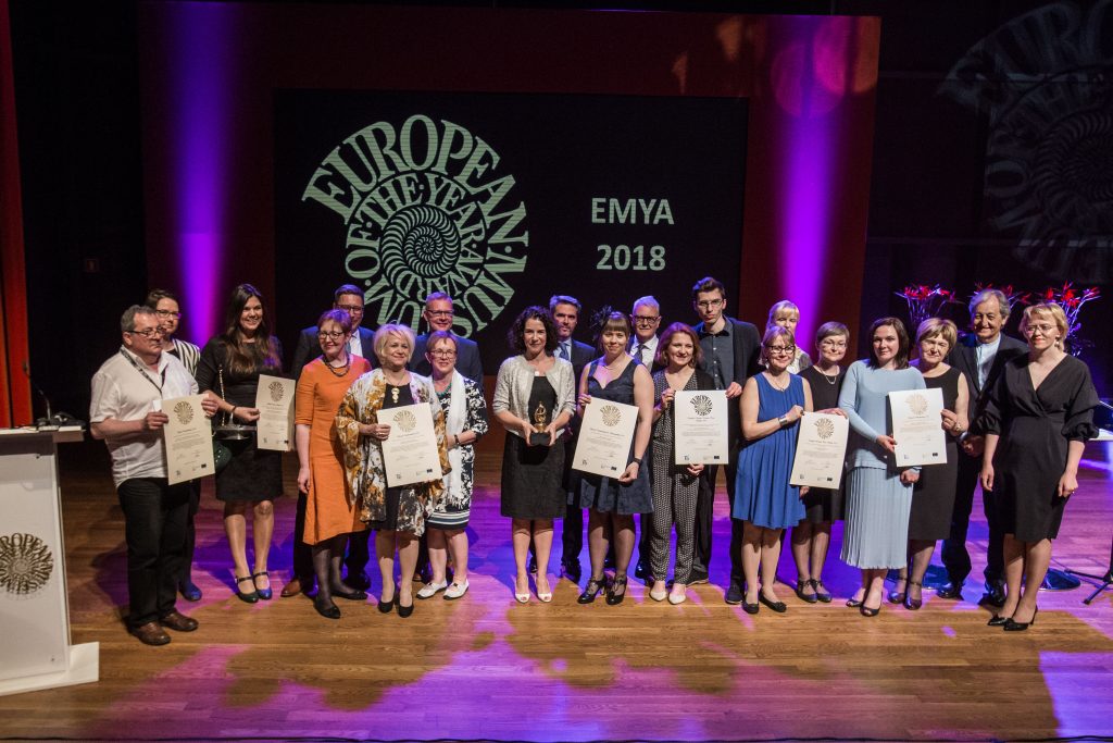 grupa elegancko ubranych ludzi prezentuje dyplomy