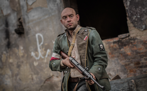 kadr z filmu, przedstawiający powstańca z bronią