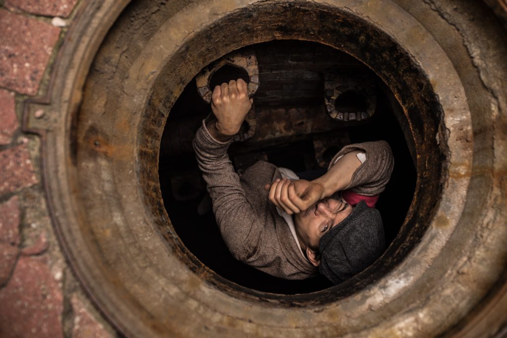 kadr z filmu przedstawiający powstańca wychodzącego z kanału