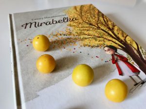 książka "Mirabelka", na której leżą mirabelki