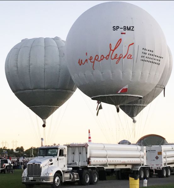 trzy startujące balony, jeden z nich ma logo niepodległa