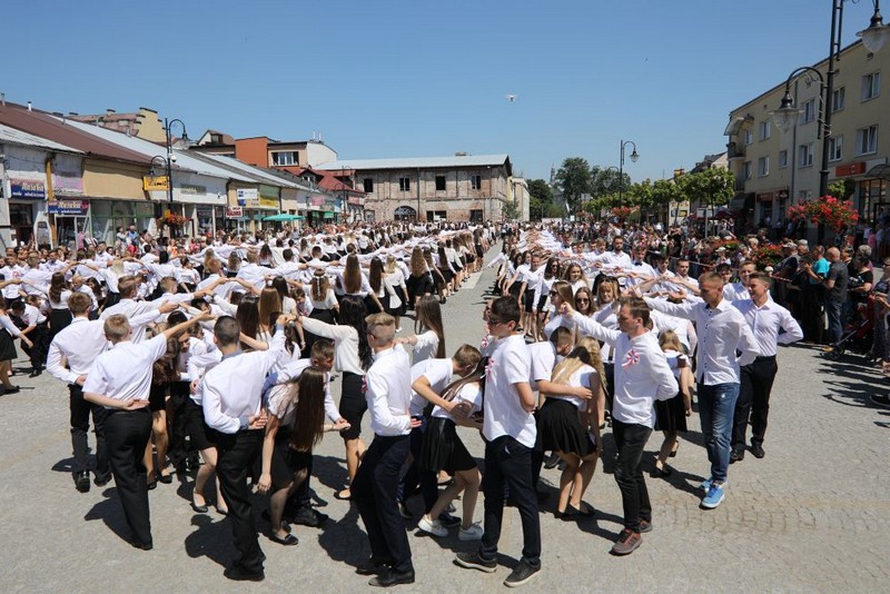 galowo ubrane pary tańczące poloneza w przestrzeni miejskiej