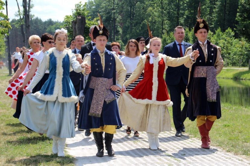 tradycyjnie ubrane pary tańczące poloneza w przestrzeni miejskiej