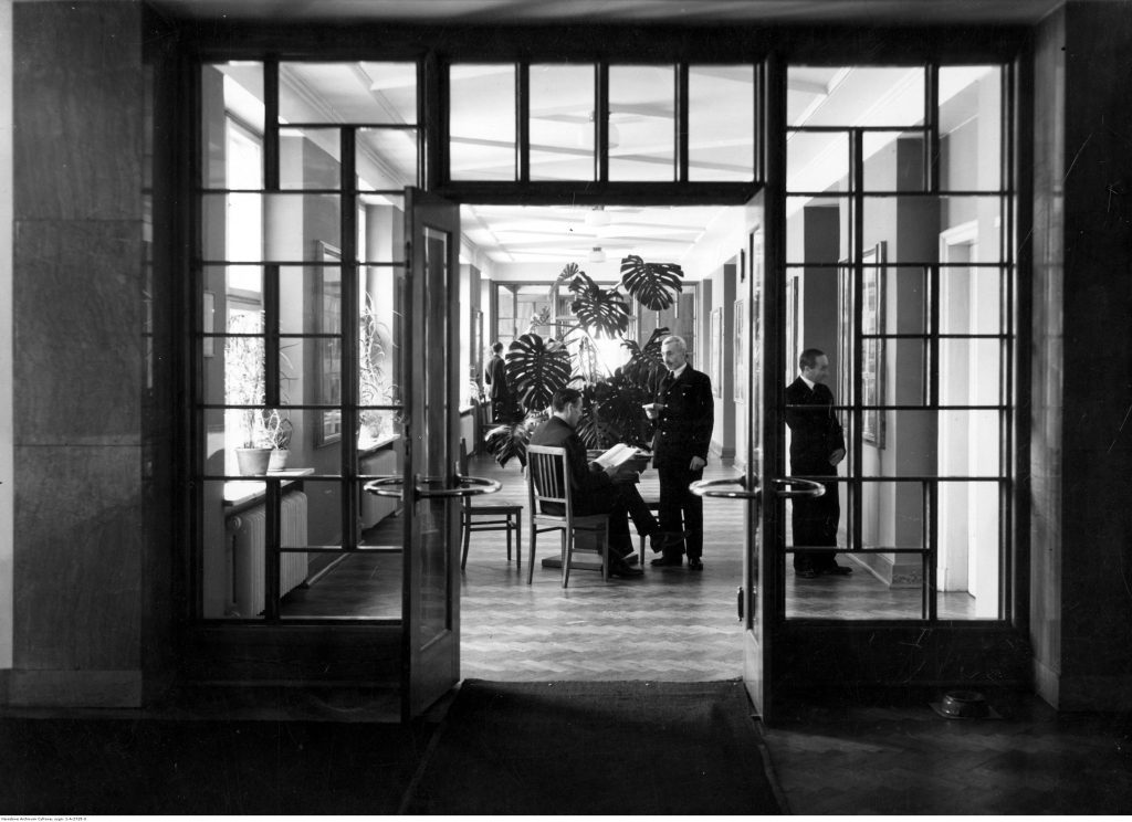 Korytarz ministerstwa, eleganckiego wystroju dopełnia dyskretnie umieszczona przy drzwiach spluwaczka, Narodowe Archiwum Cyfrowe