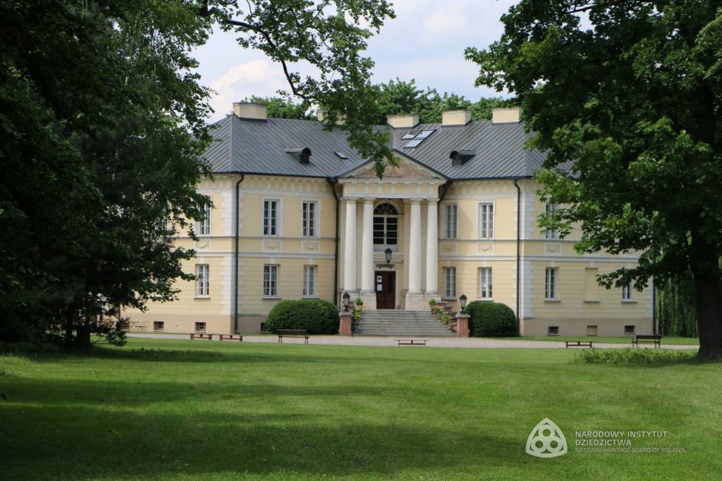 widok na pałac zza drzew liściastych