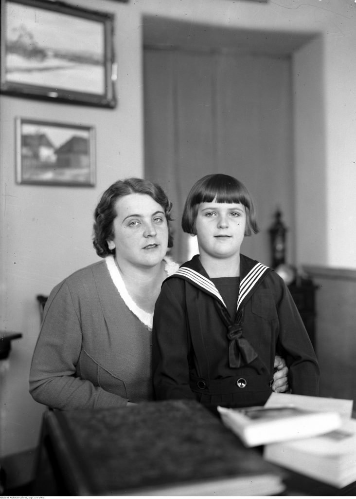 czarno-białe zdjęcie przedstawiające matkę z synem w stroju marynarskim