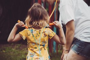 dziecko stoi na łące ze skakanką w dłoniach