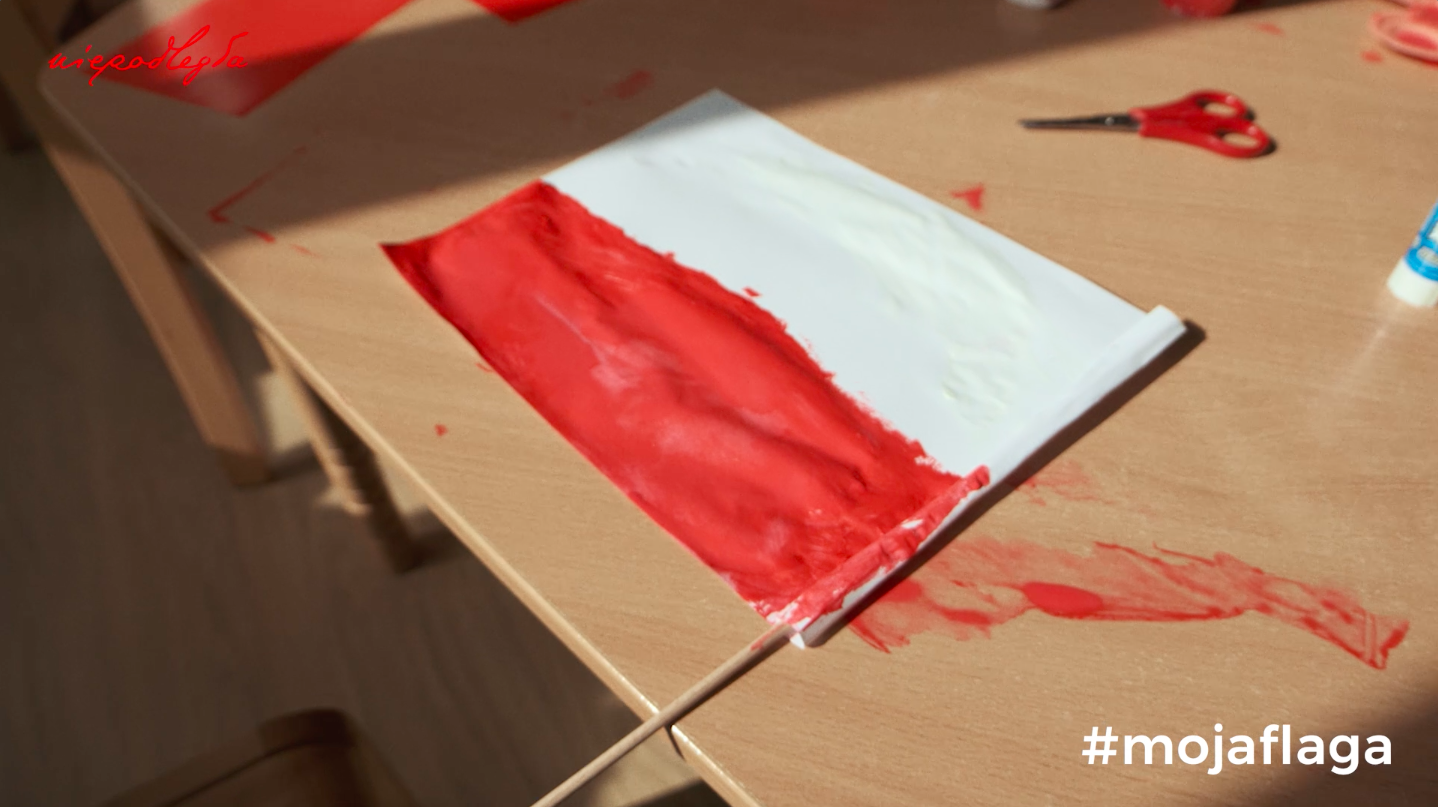 pomalowana farbkami mała flaga schnie na umazanym stoliku