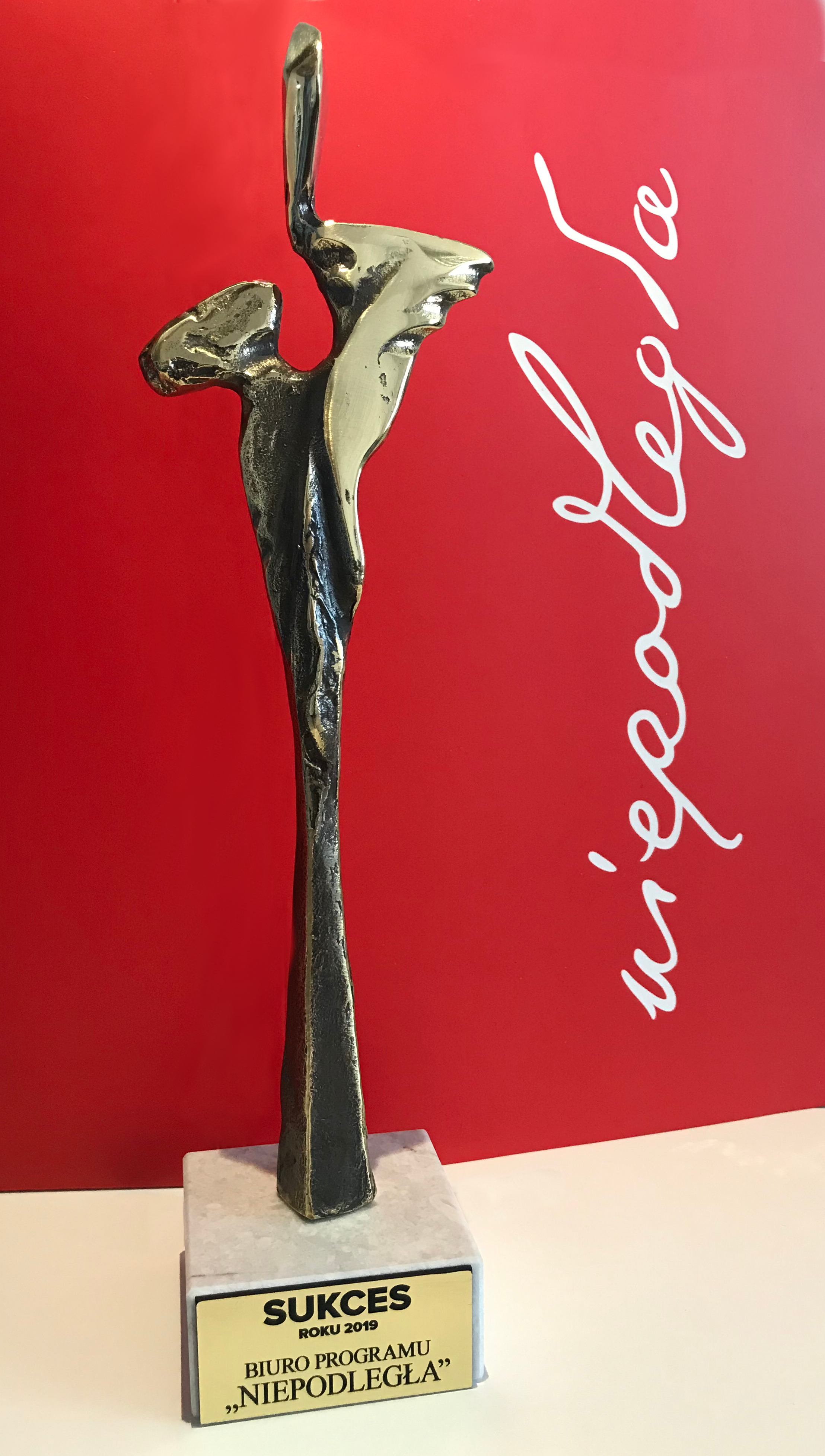 statuetka "Sukces roku 2019" na tle logo "Niepodległa"
