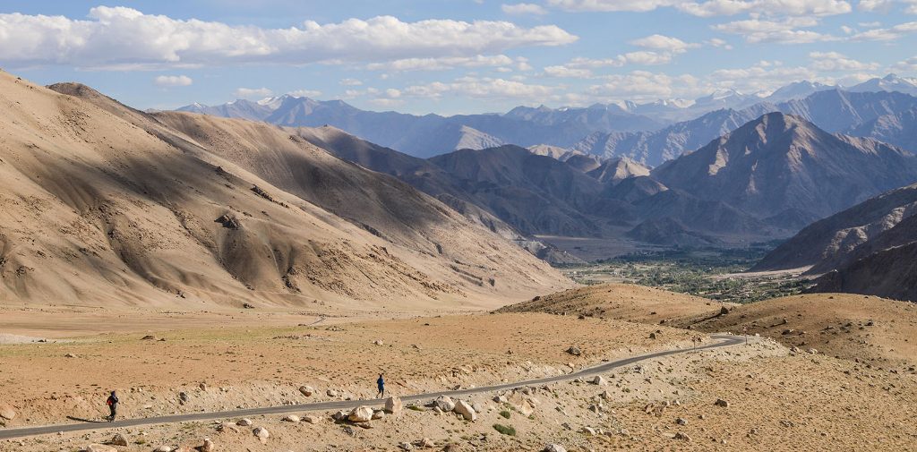 mali biegacze na drodze wśród gór