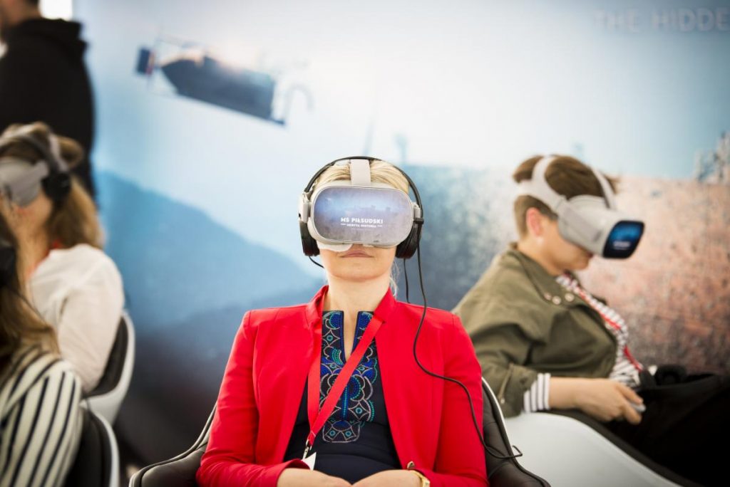 Zdjęcie promocyjne Wirtualnego Teatru "Niepodległa" - kilka osób siedzących w goglach do VR z napisem MS Piłsudski