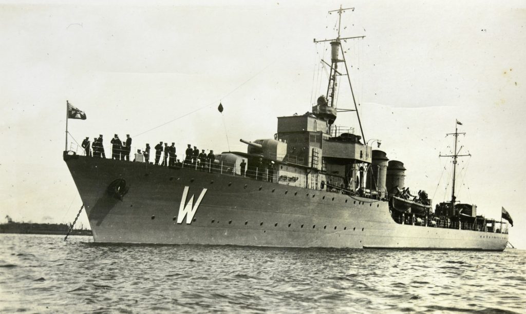 okręt wojskowy w porcie z widocznymi marynarzami na pokładzie