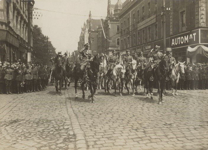 oddział konny jadący po ulicach miasta na archiwalnym zdjęciu