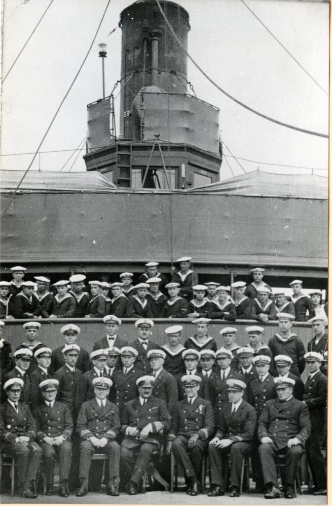 marynarze i kadra oficerska pozująca do zdjęcia przy okręcie