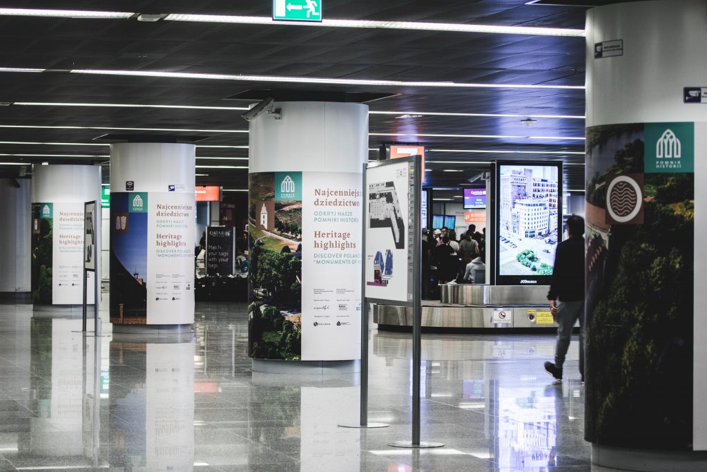 słupy w przestrzeni lotniska opatulone w folie z wystawą