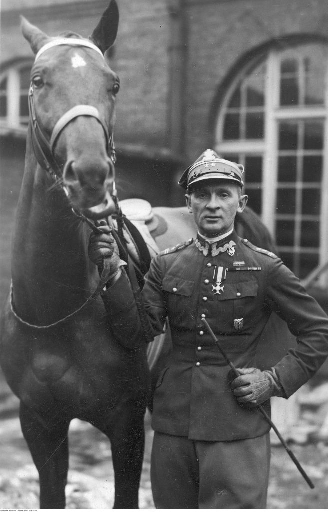 Karol Rómmel, podpułkownik kawalerii WP w mundurze, jeździec - fotografia sytuacyjna (stoi obok konia).