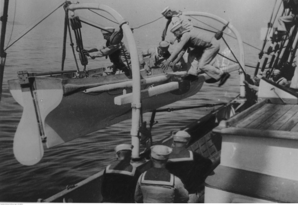 Alarm "Człowiek za burtą" na pokładzie szkunera ORP "Iskra". Marynarze wskakują do szalupy ratunkowej.