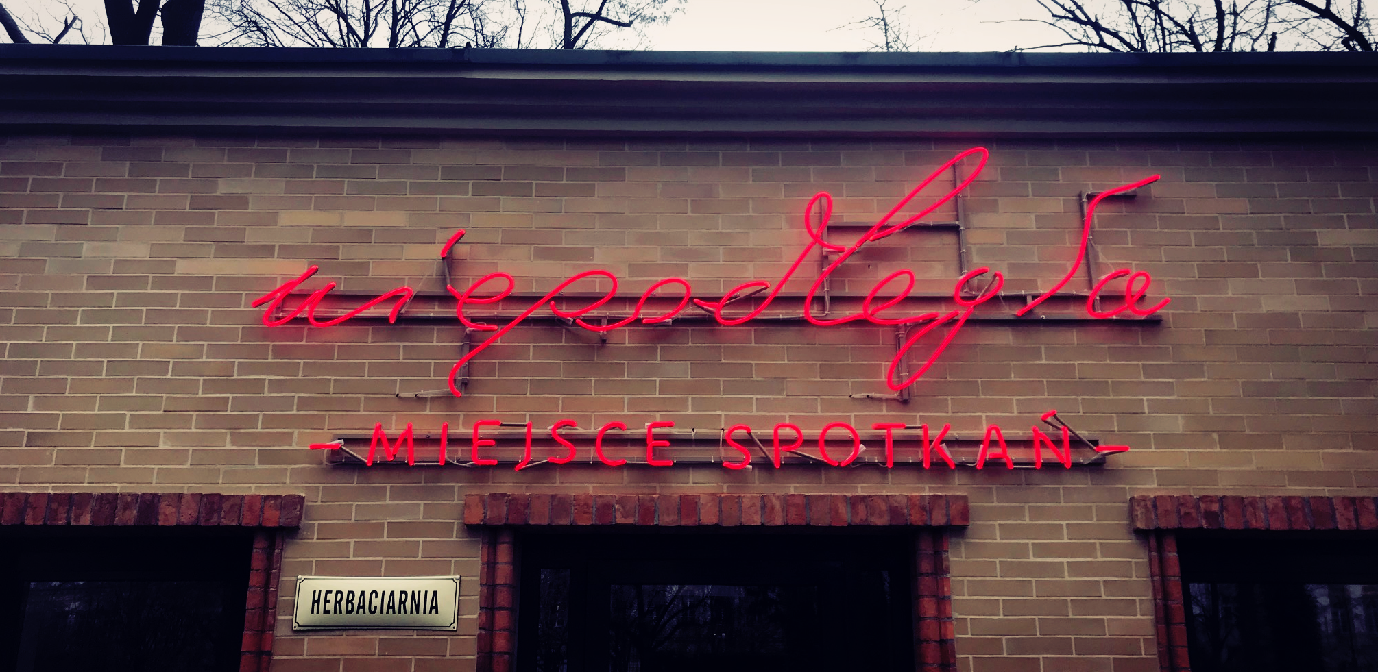 neon na fasadzie ceglanej ściany