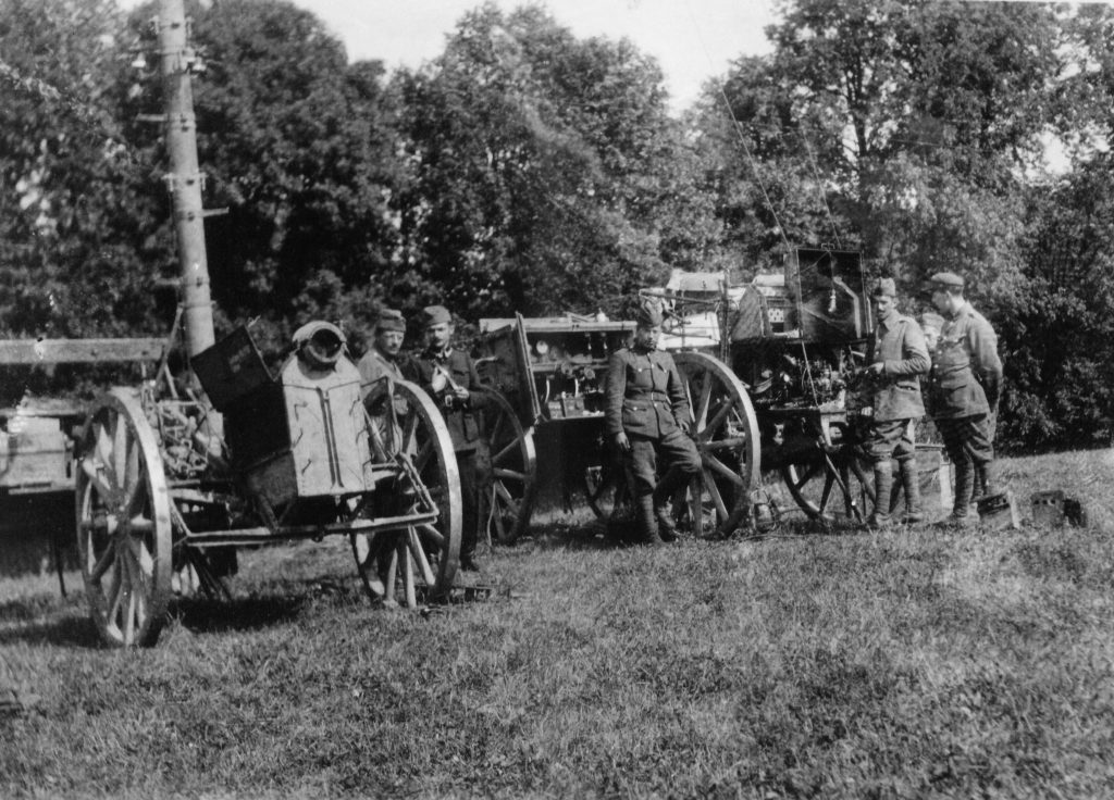 żołnierze przy wozach polowych z elelmentami radiostacji