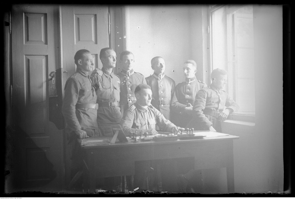 Grupa wojskowych w wnętrzu budynku.