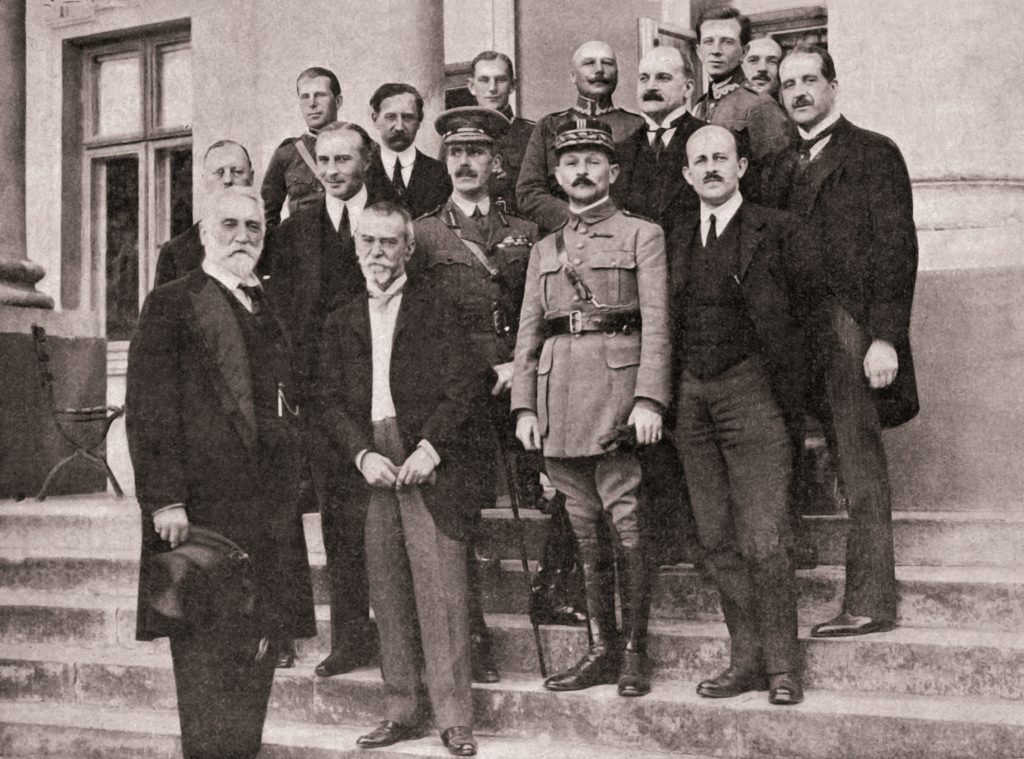 grupa mężczyzn w oficjalnych strojach na schodach przed budynkiem
