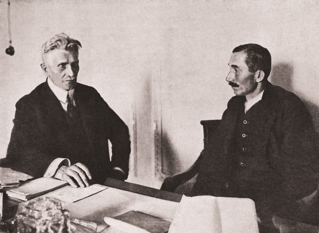 dwóch meżczyzn przy stole z dokumentami