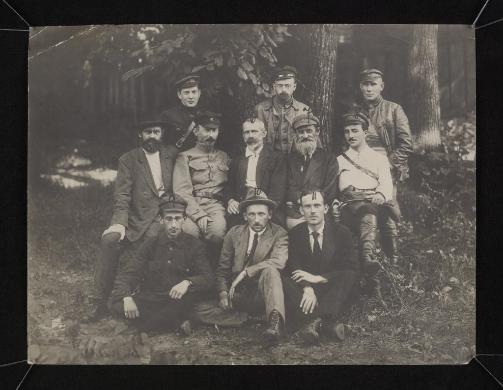 grupa ludzi pozująca do zdjęcia grupowego w lesie