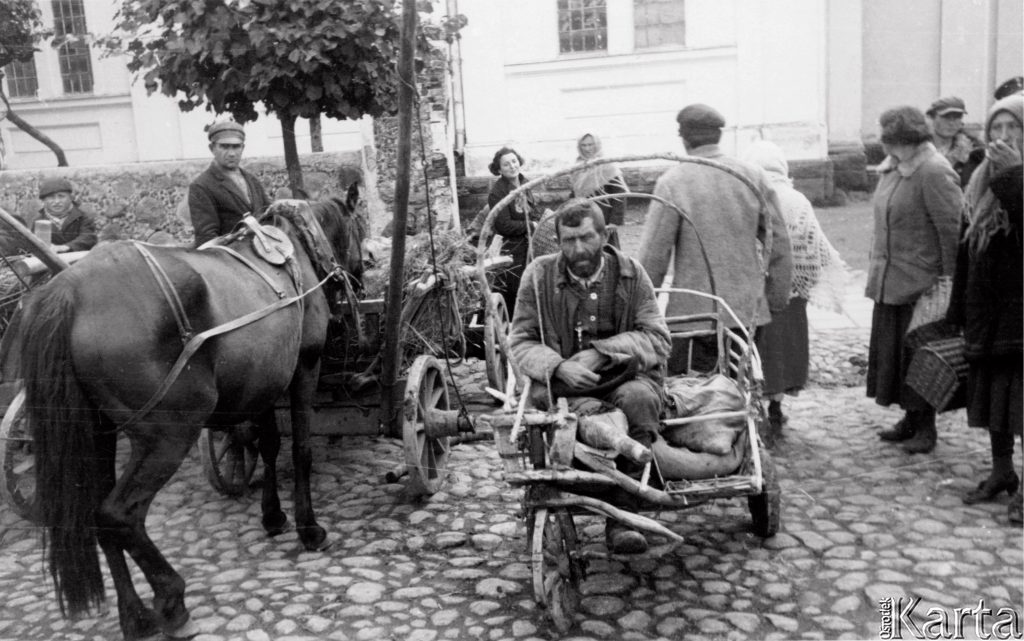 okaleczony mżczyzna siedzący na wózku okbok koń i ludzie