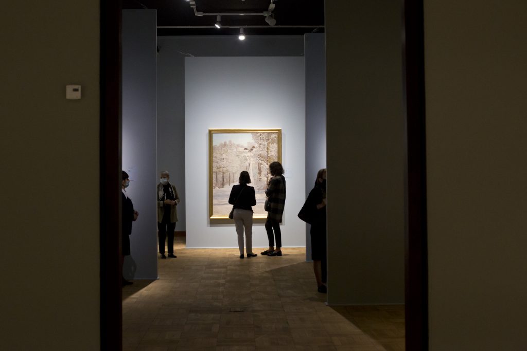 sala wystawowa z rozproszoymi ludźmi oglądającymi obrazy