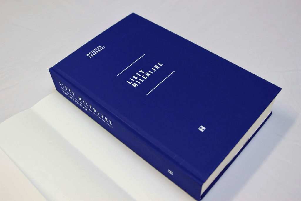 Fotografia przedstawia granatową okładkę książki zatytułowanej "Listy Milenijne" autorstwa Wojciecha Kucharskiego. W tle znajduje się biała obwoluta książki