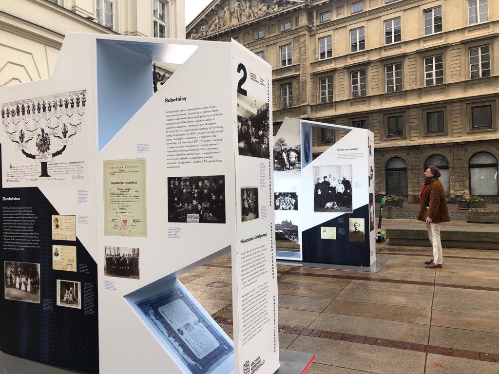 ekspozytory wystawy obok pomnika, na ulicy