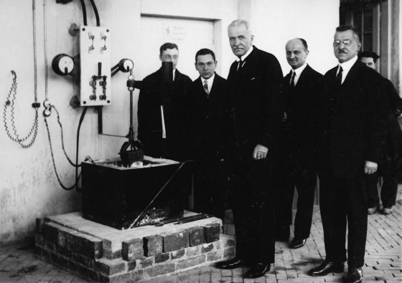 5 elegancko ubranych mężczyzn przed urządzeniem technicznym