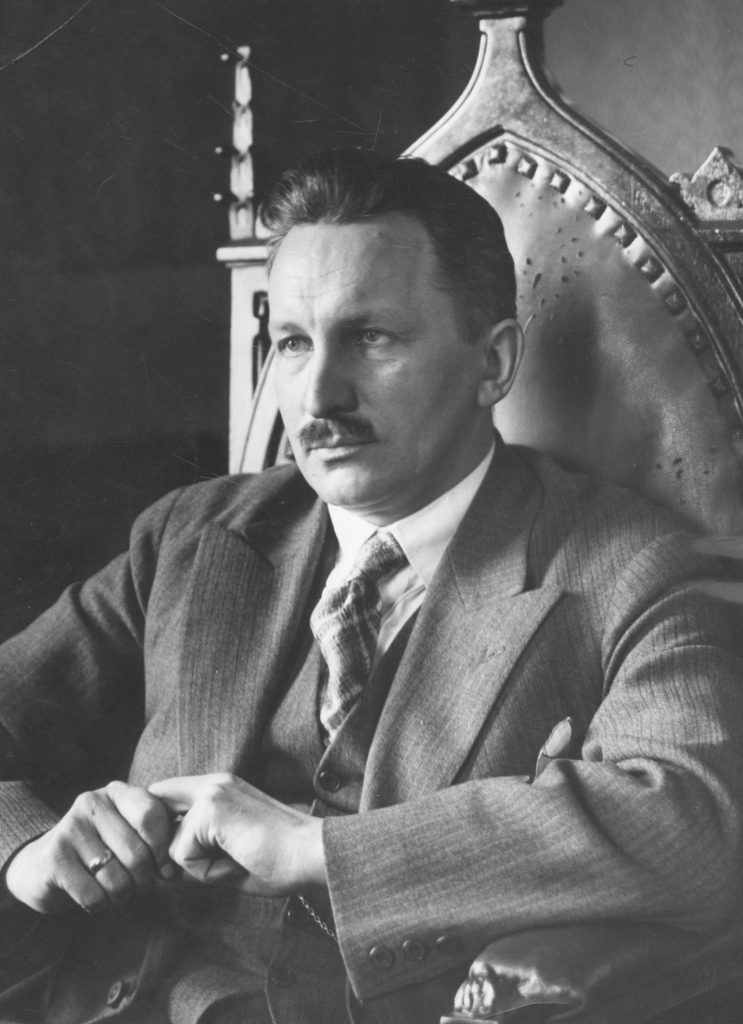 mężczyzna w garniturze siedzący na ozdobnym krześle