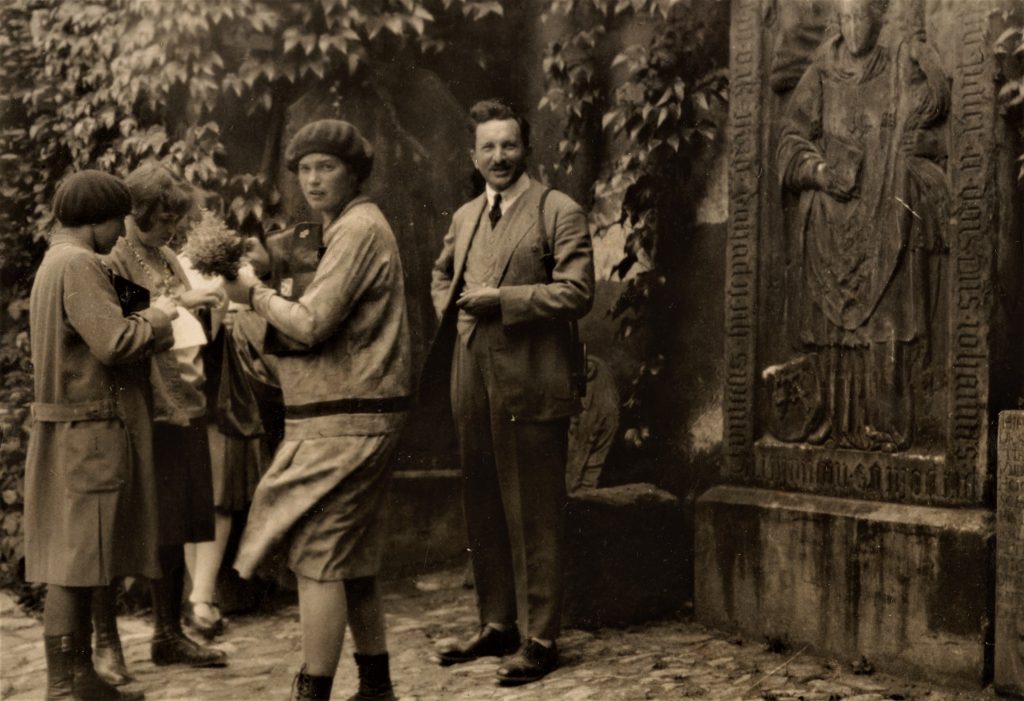 gruoa ludzi przed domem