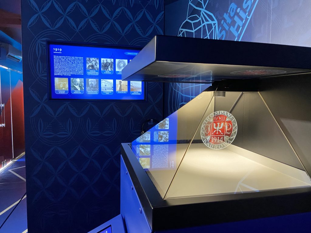 zdjęcie ukazujące piramidę holograwiczną i ekran multimedialny i fragment dekoracji graficznej wnętrza tira