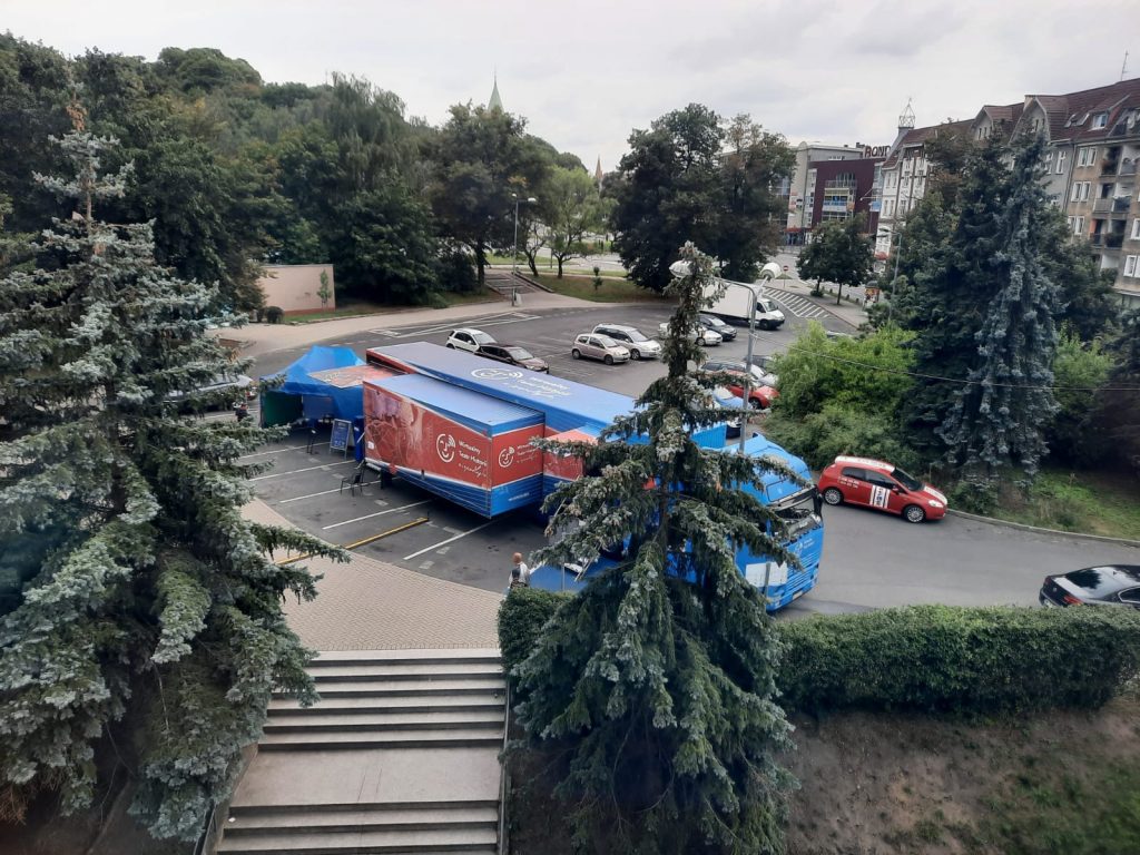 rozstawiony samochód ciężarowy z wystawą zaparkowany na miejskim parkingu