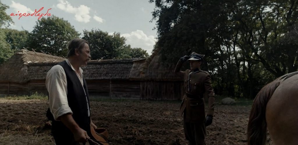 oficer na świeżo zaoranym polu salutuje przed chłopem podczas orki