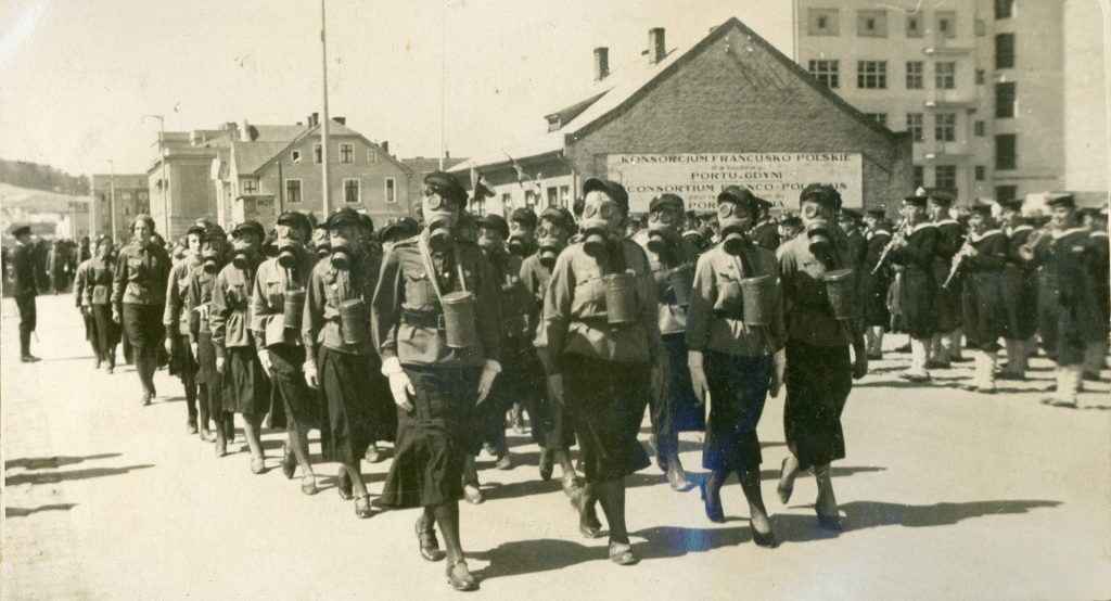 kobiety w maskach gazowych podczas defilady