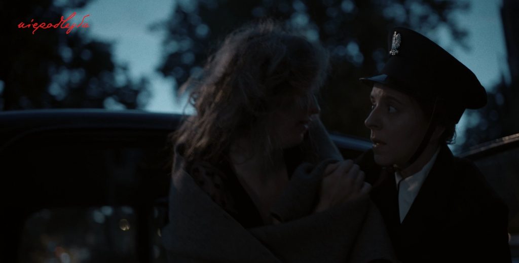 policjantka pomaga kobiecie wysąść z samochodu