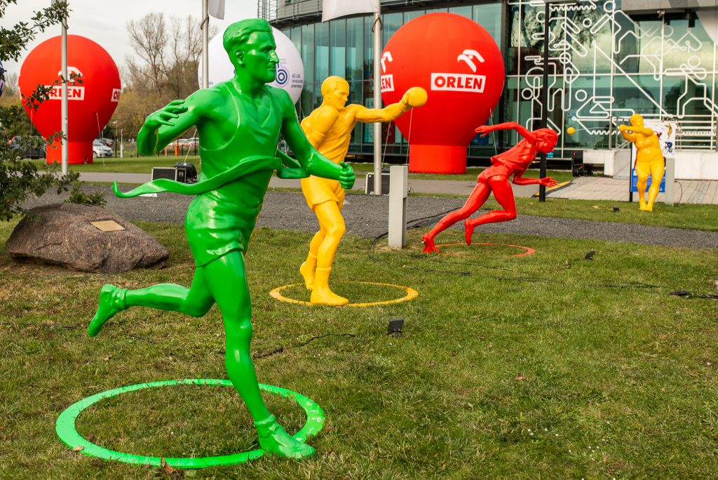 rzeźby na trawniku przed szklanym budynkiem PKOl