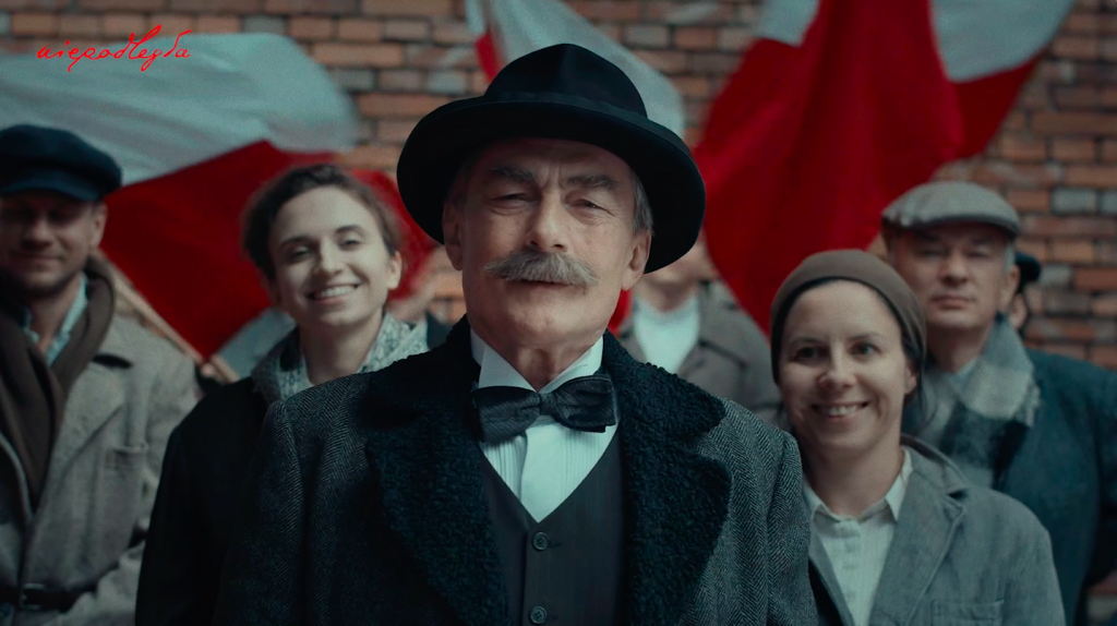 Daszyński na pierwszym planie, za nim robotnicy uśmiechający się i machający flagami