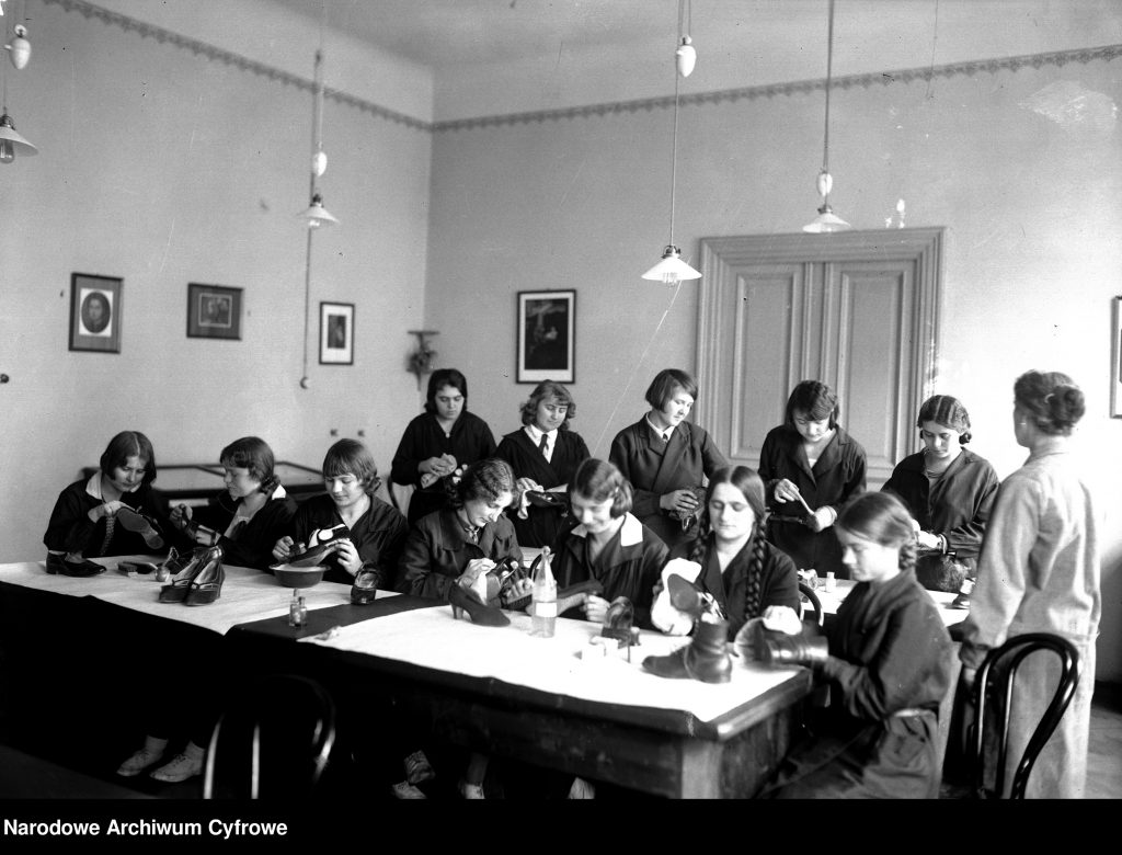 klasa dzewcząt usadzonych przy ławkach i czyszczących buty